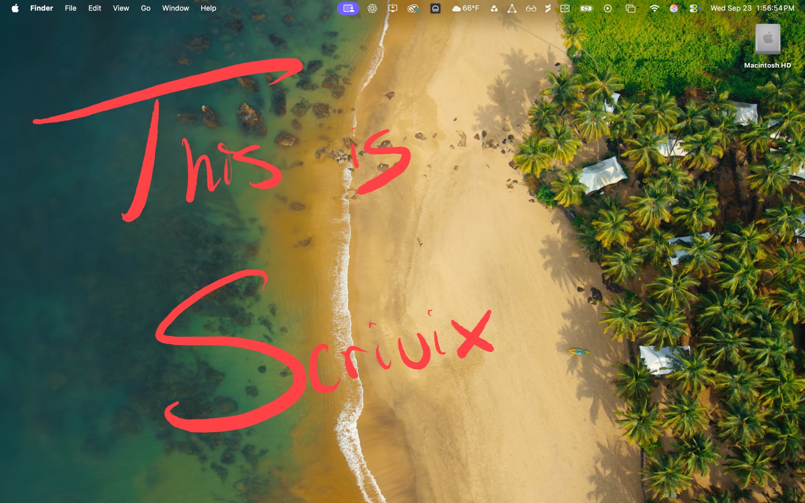 The Mac display showing the same red handwriting over a beach wallpaper